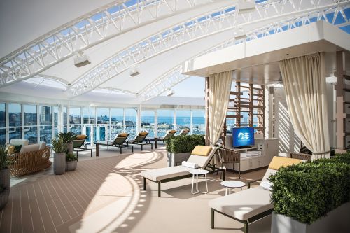 Sun chairs and cabanas under a retractable roof onboard a cruise ship