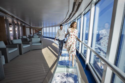A glass walkway onboard a cruise ship with the ocean underneath