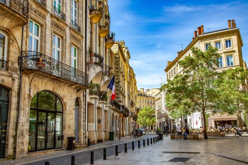 A French street in Bordeaux lined with tall colonial buildings 