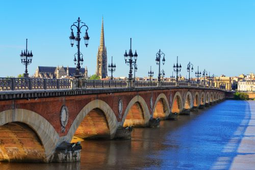 An old bridge in Bordeaux with a Cathedral in the background
