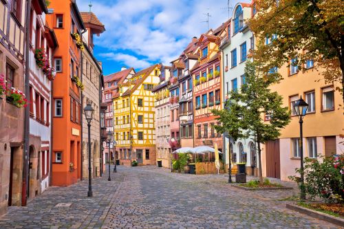 A cobblestone street in Europe lined with old historic buildings