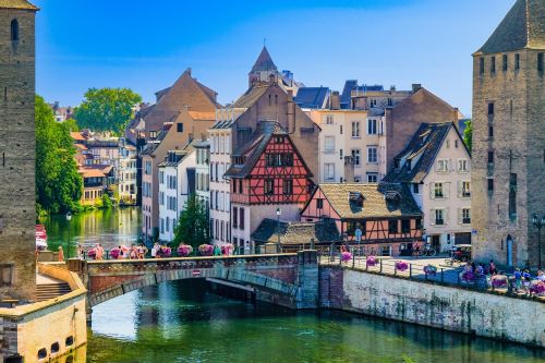 Old style European buildings and houses with a brigde crossing over a river 