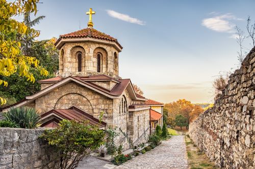 A limestone church with a gold cross in an old fortress 
