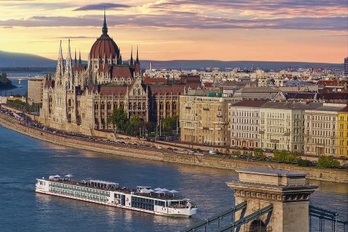A Viking vessel cruising down the river in Budapest with the magnificent parliament building in the background