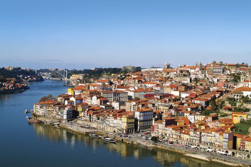 The  Douro River passing along terracotta-roofed buildings in Porto. 