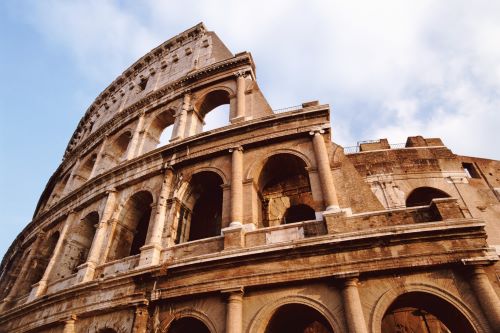 A part of the Colosseum close up with clouds in the sky